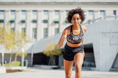 Afro atlet kadın dışarıda koşuyor..