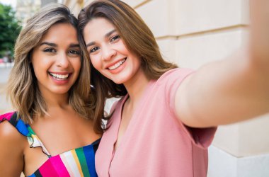 İki arkadaş dışarıda selfie çekiyor..