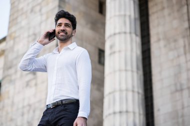 İş adamı dışarıda telefonla konuşuyor..