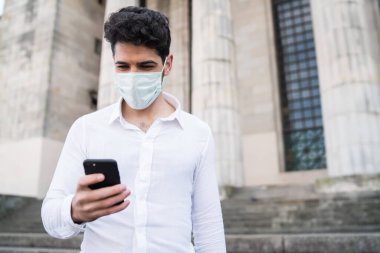 İş adamı cep telefonunu açık havada kullanıyor..