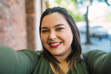 Genç ve cüsseli kadın selfie çekiyor..