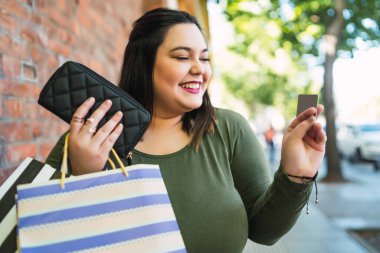 Genç bir kadın kredi kartıyla alışveriş yapıyor..