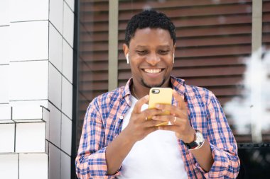 Sokakta telefonunu kullanan Afrikalı Amerikalı bir adam..