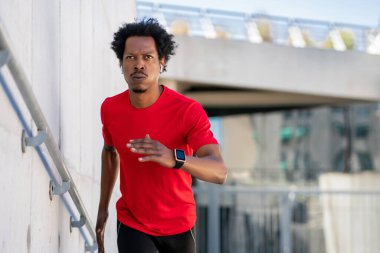 Atletik adam koşuyor ve dışarıda egzersiz yapıyor..