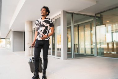 Dışarıda yürürken bavul taşıyan bir turist..