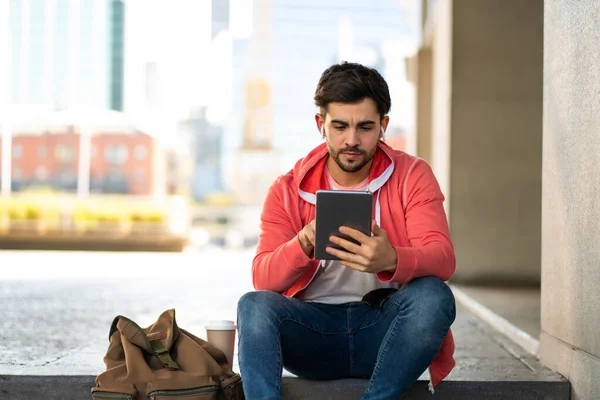 Νεαρός που χρησιμοποιεί ψηφιακό tablet σε εξωτερικούς χώρους. — Φωτογραφία Αρχείου
