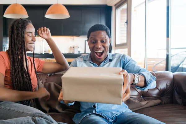 Donna sorprende il suo fidanzato con un regalo. — Foto Stock