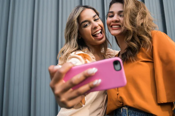 Dois amigos tomando selfie com telefone ao ar livre. — Fotografia de Stock