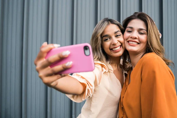 Dois amigos tomando selfie com telefone ao ar livre. — Fotografia de Stock