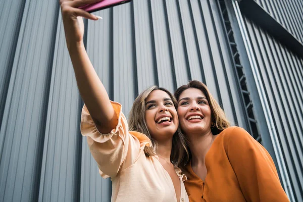 Dois amigos tomando selfie com telefone ao ar livre. — Fotografia de Stock