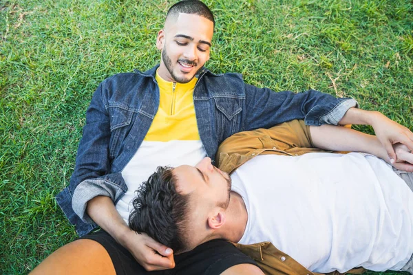 Schwules Paar legt sich auf das Gras im Park. — Stockfoto