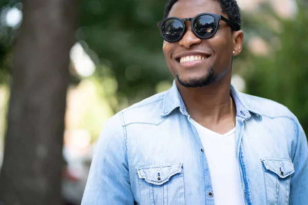 Hombre sonriendo mientras está parado al aire libre. — Foto de Stock