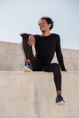 Afro atletik adam egzersizden sonra dinleniyor..