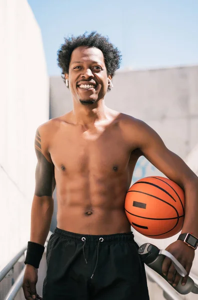 Afro atleta hombre sosteniendo una pelota de baloncesto al aire libre. —  Fotos de Stock