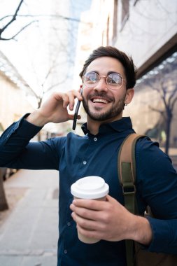 Genç adam dışarıda telefonla konuşuyor..