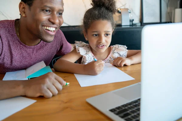 Een vader die zijn dochter helpt met thuisonderwijs. — Stockfoto