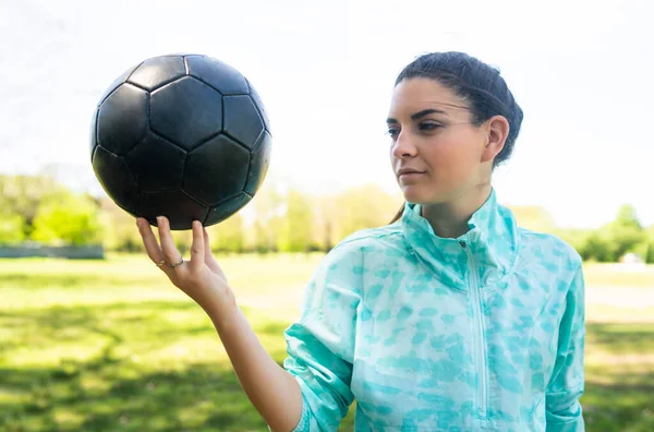 Junge Fußballerin steht mit Ball auf dem Feld. — Stockfoto