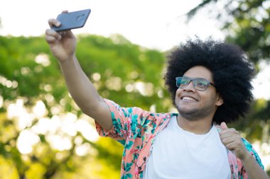 Latin adam dışarıda telefonla selfie çekiyor..