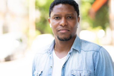 Dışarıda yürürken gülümseyen Afrikalı Amerikalı adam..