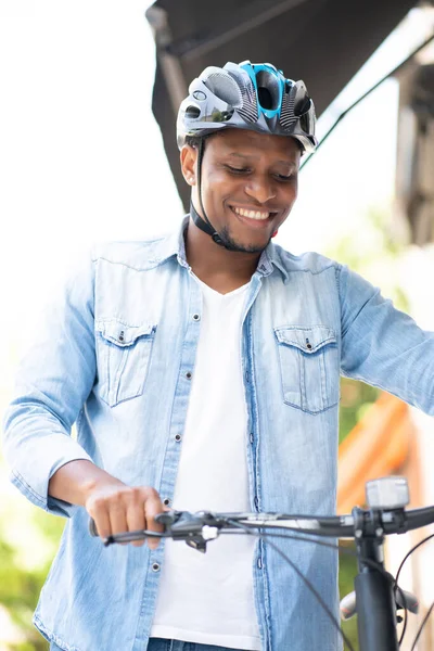 Man draagt een helm tijdens het lopen met een fiets. — Stockfoto