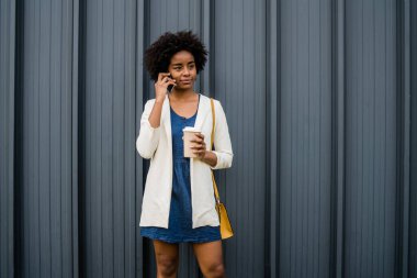 İş kadını dışarıda telefonla konuşuyor..