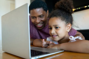 Bir baba kızına ev okulunda yardım ediyor..