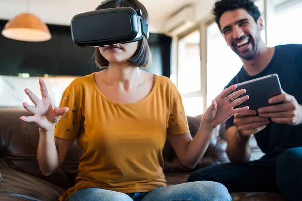 Couple playing video games with VR glasses.