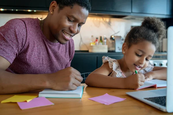 Een vader die zijn dochter helpt met thuisonderwijs. — Stockfoto