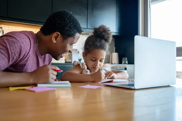 Un padre che aiuta sua figlia con la scuola di casa. — Foto Stock