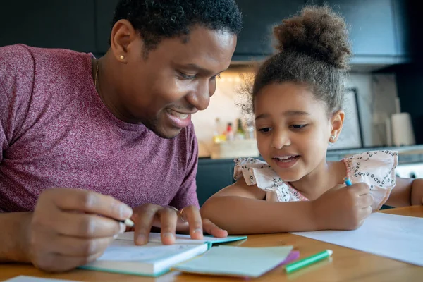 Un padre che aiuta sua figlia con la scuola di casa. — Foto Stock