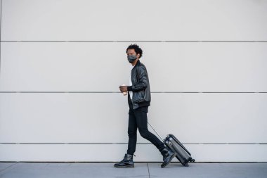 Dışarıda yürürken bavul taşıyan bir turist..