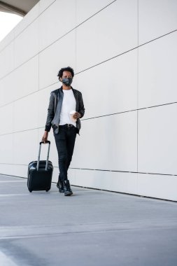 Dışarıda yürürken bavul taşıyan bir turist..