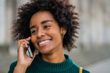İş kadını dışarıda telefonla konuşuyor..