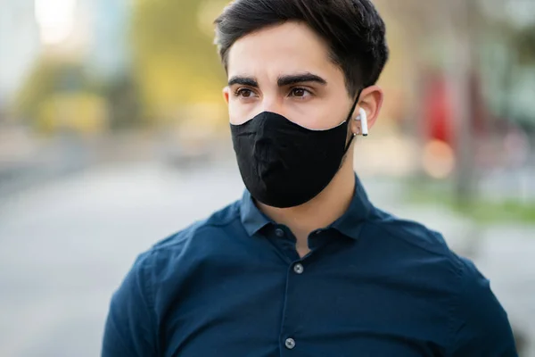 Portrait of young man wearing face mask outdoors. — Stock Photo, Image