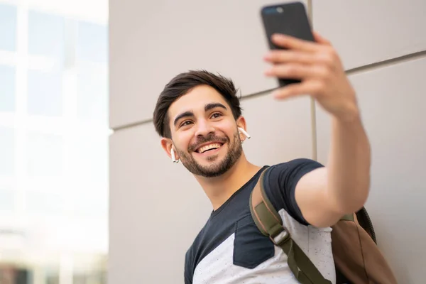 Portrét mladého muže se selfie s telefonem venku. — Stock fotografie
