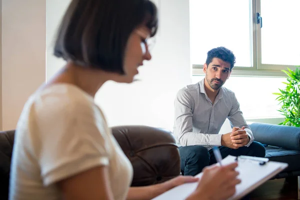 Psycholoog maakt aantekeningen tijdens therapiesessie. — Stockfoto