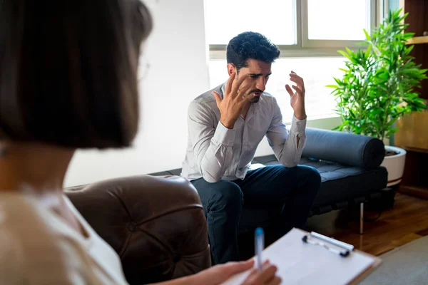 Psycholoog maakt aantekeningen tijdens therapiesessie. — Stockfoto