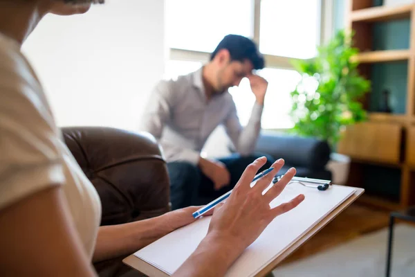 Psycholog robi notatki podczas sesji terapeutycznej. — Zdjęcie stockowe