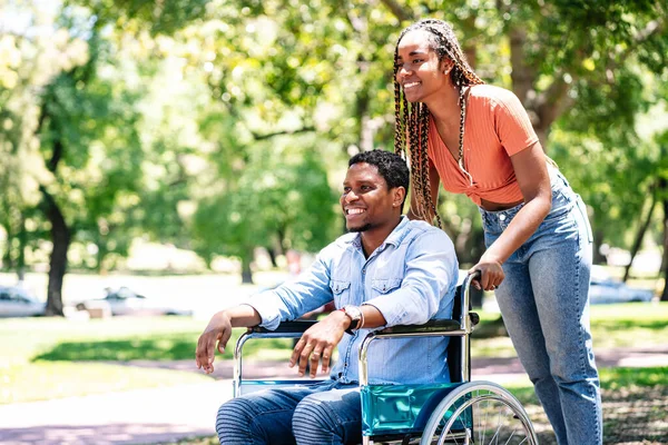 Mann im Rollstuhl genießt Spaziergang mit Freundin. — Stockfoto