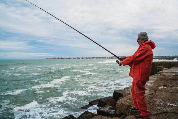 Stary człowiek łowiący ryby w morzu.. — Zdjęcie stockowe