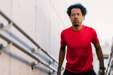 Afro atletik adam dışarıda egzersiz yapıyor..