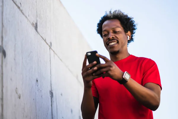 Idrottare som använder sin mobiltelefon utomhus. — Stockfoto