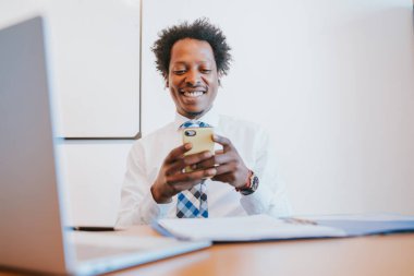 Afro İşadamı cep telefonunu kullanıyor..