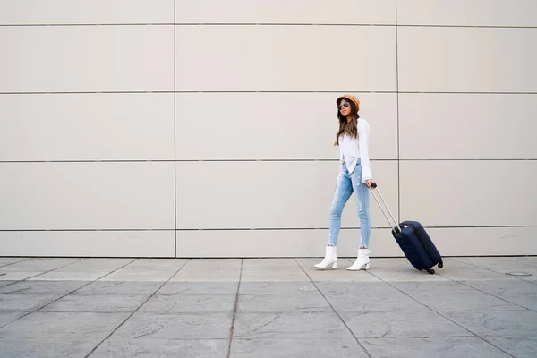 Egy fiatal nő bőröndöt cipel a szabadban.. — Stock Fotó