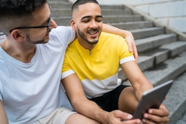 Dijital tablet kullanan eşcinsel çift.