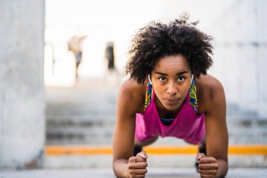 Afro atlet kadın dışarıda şınav çekiyor..