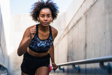Afro atlet kadın dışarıda koşuyor..