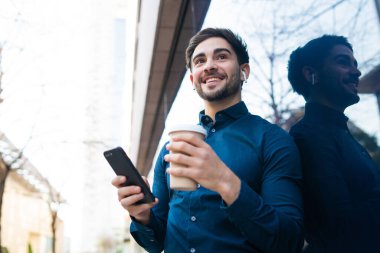 Genç adam cep telefonunu açık havada kullanıyor..