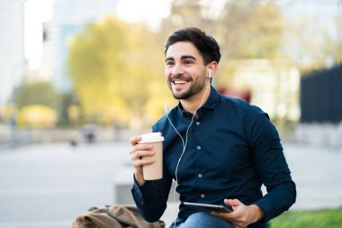 Genç adam dışarıda dijital tablet kullanıyor..