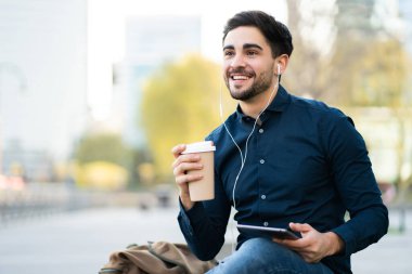 Genç adam dışarıda dijital tablet kullanıyor..